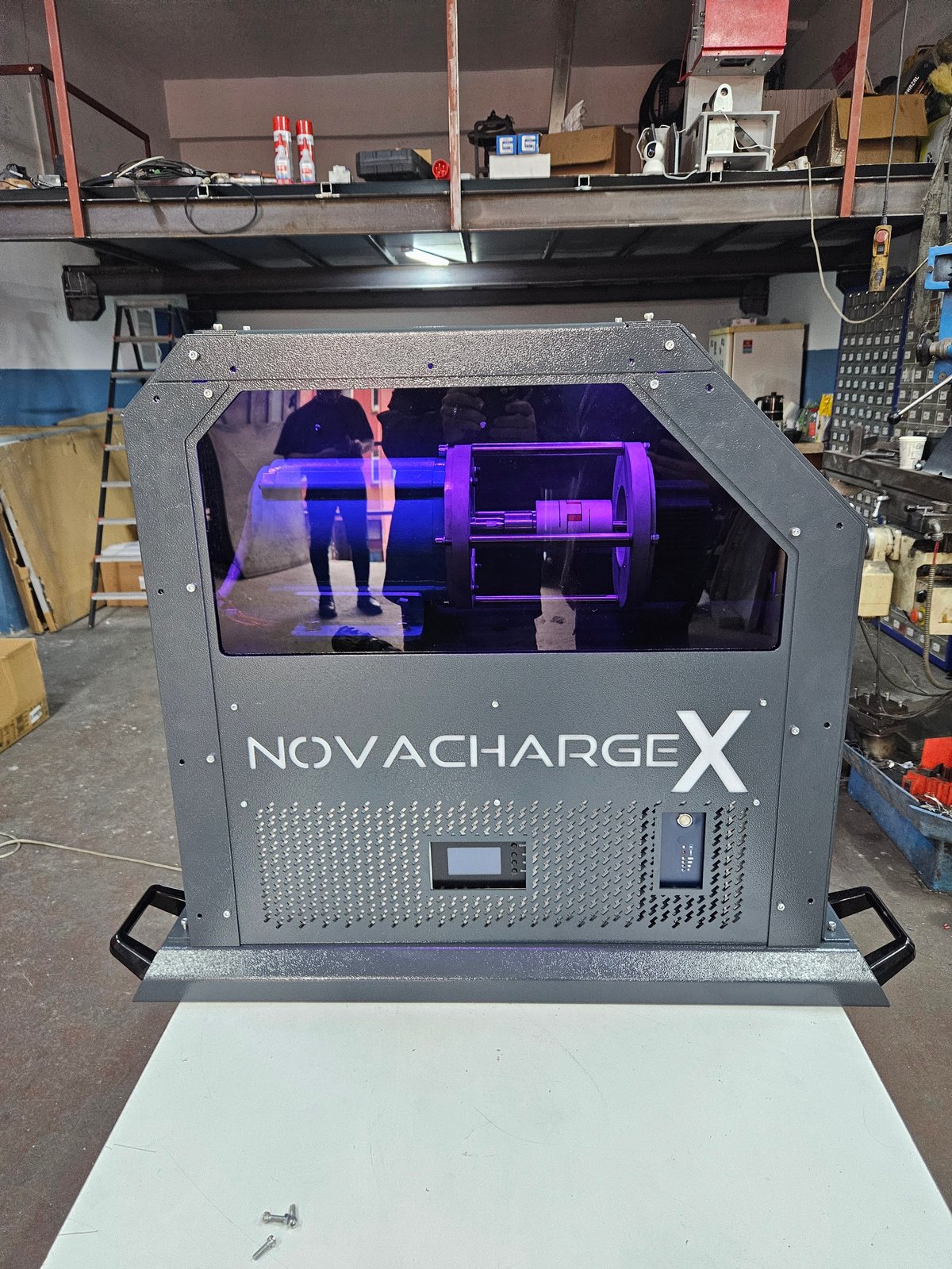 NovaChargeX 3D printer in workshop with purple-lit chamber displaying a model interior scene