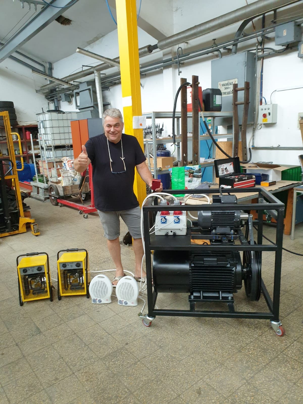 Man standing in workshop next to industrial generators and equipment displays